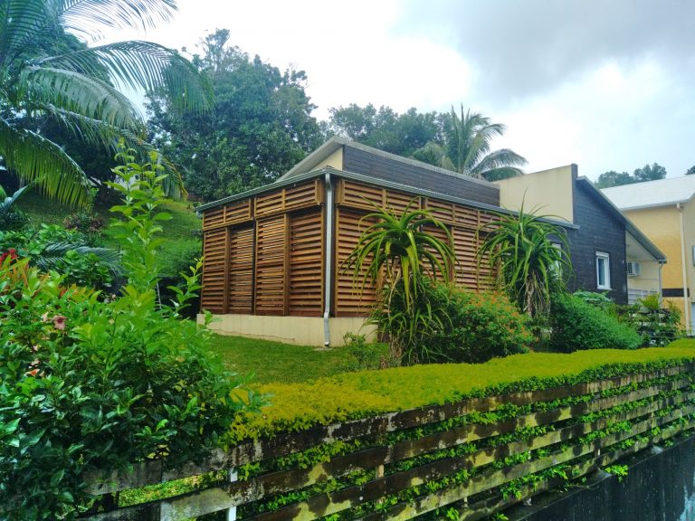 Clôture brise-vue en bois bordant un jardin en pente