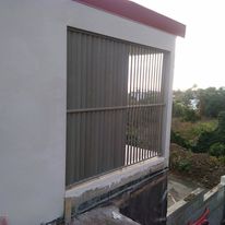 Grille en bois posée sur une ouverture de façade