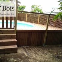 Terrasse en bois avec escalier et garde-corps près du bassin