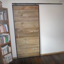 Porte coulissante en bois installée dans une pièce de vie