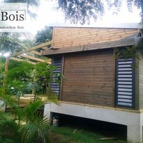 Petite construction en bois avec varangue dans un jardin